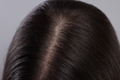 Closeup view of healthy woman`s hair on grey background