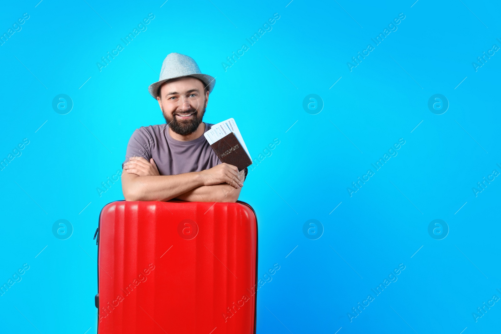 Photo of Man with suitcase and passport on color background. Space for text