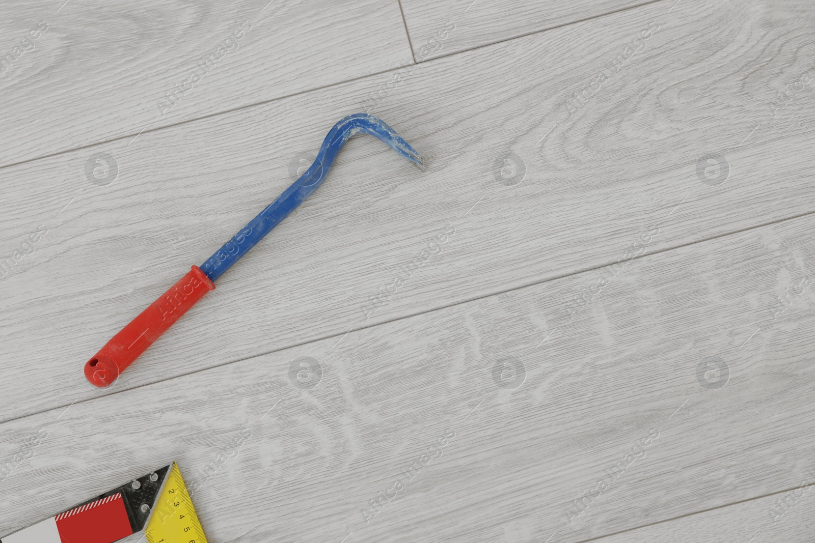 Photo of Nail puller on laminate flooring, top view. Space for text