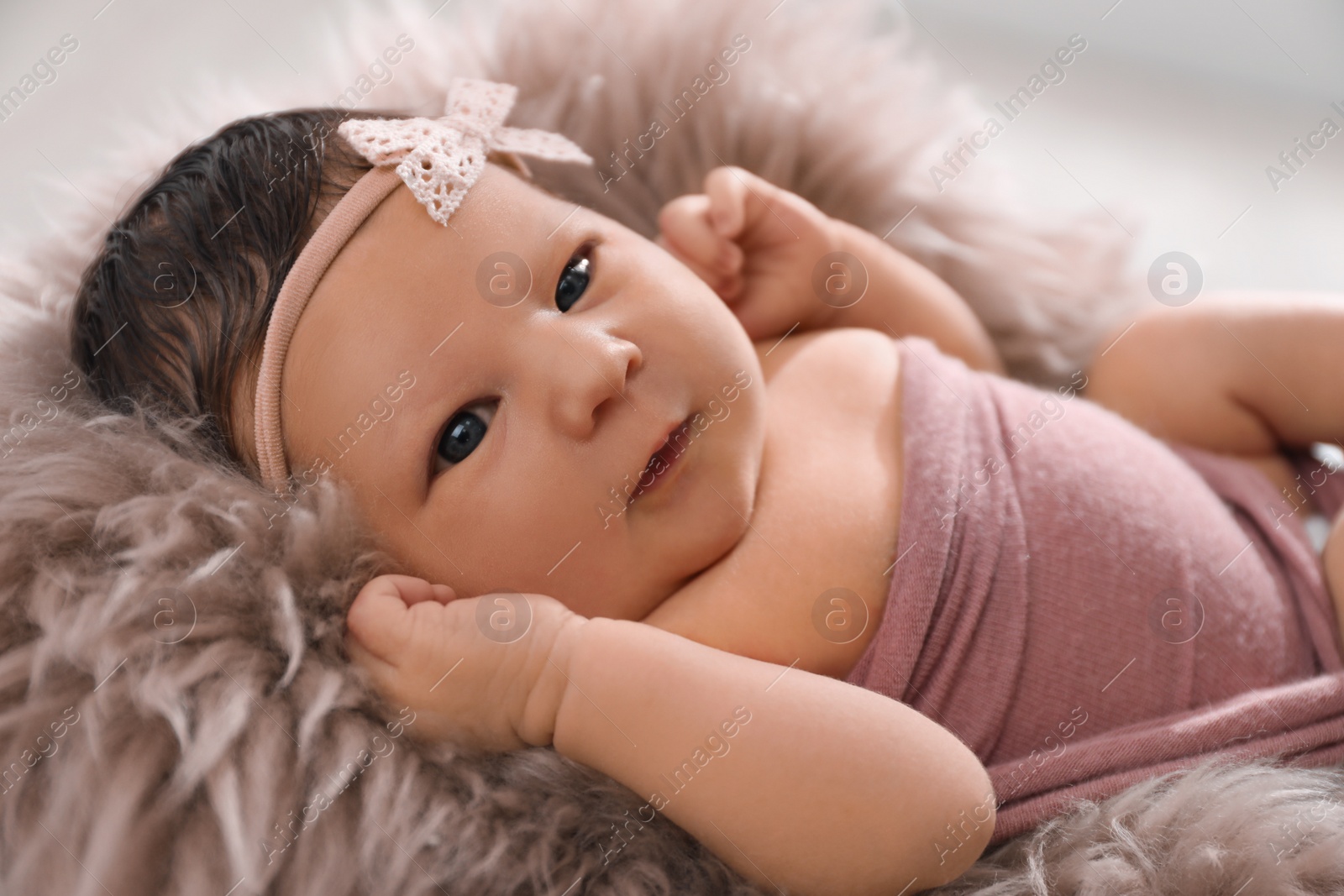 Photo of Cute newborn baby lying on fuzzy blanket, closeup