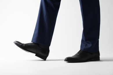 Photo of Businessman in leather shoes on white background, closeup