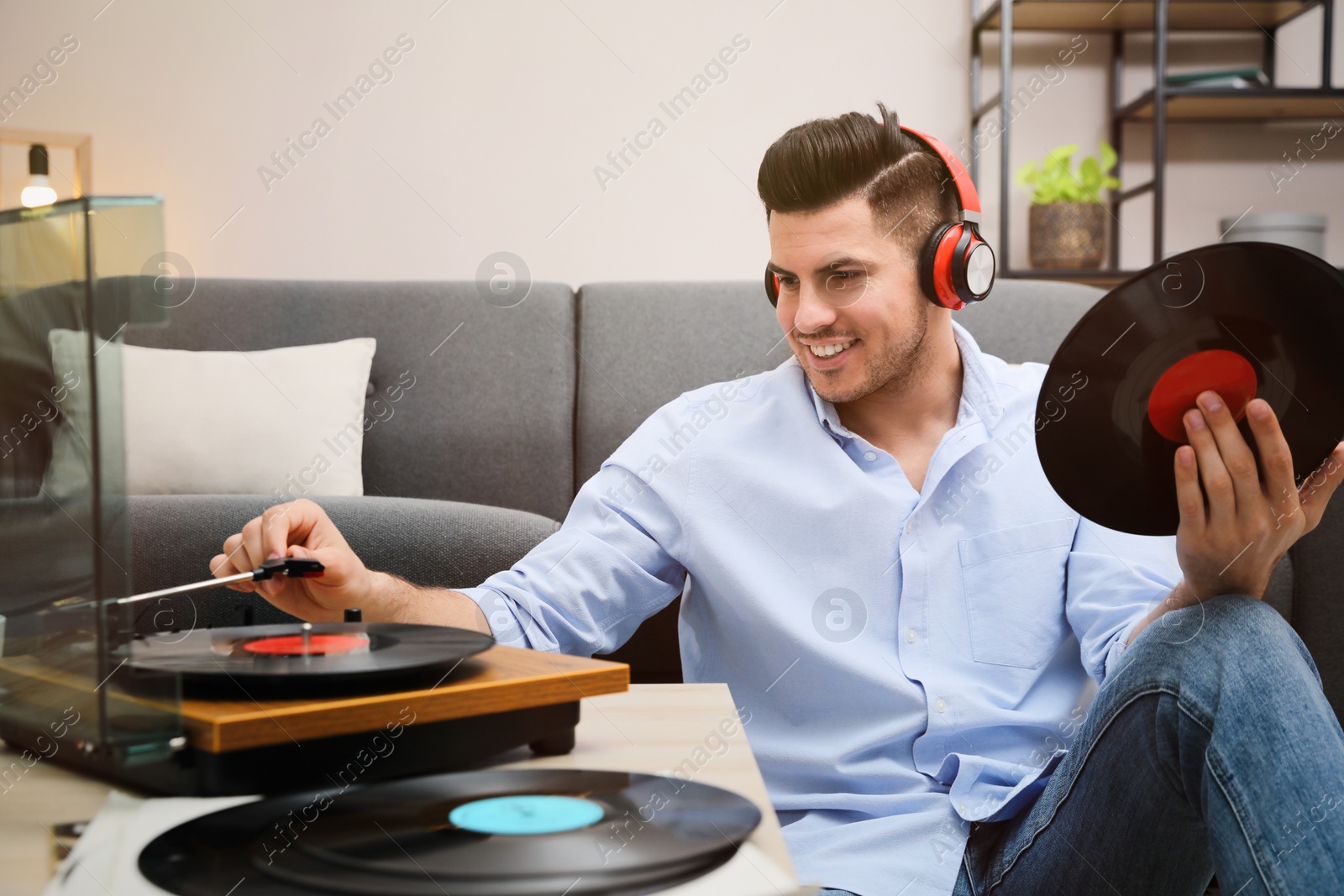 Photo of Happy man listening to music with turntable at home