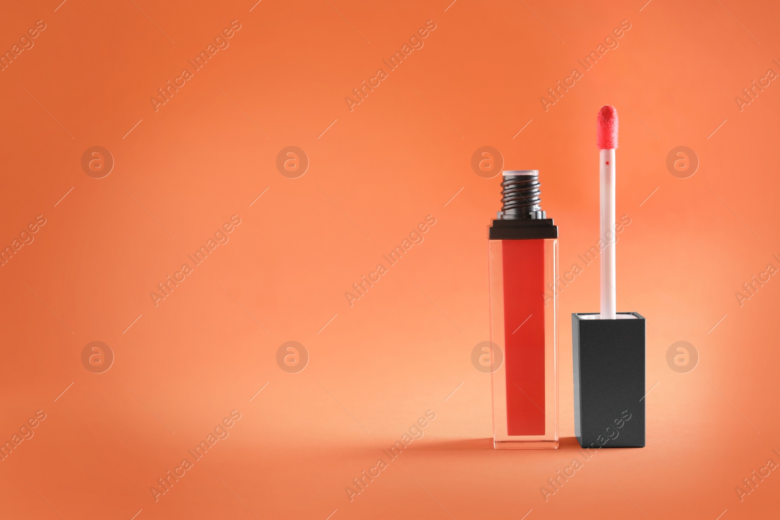 Photo of Applicator with liquid lipstick tube on color background. Space for text