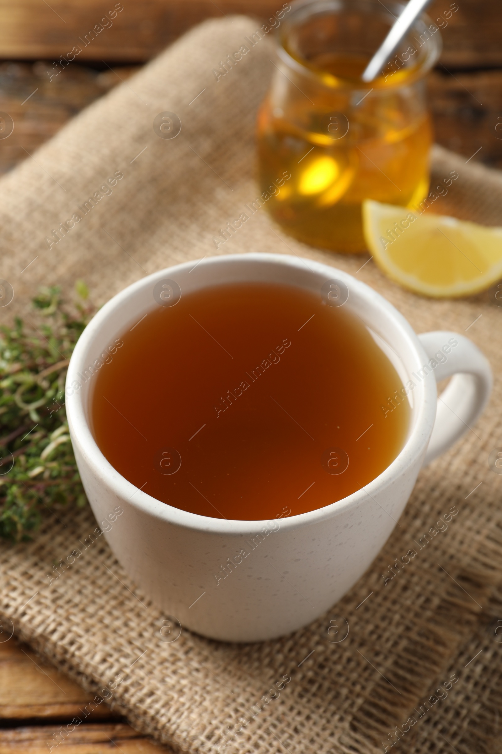 Photo of Aromatic herbal tea with thyme on wooden table