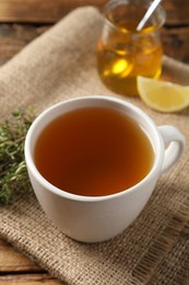 Aromatic herbal tea with thyme on wooden table