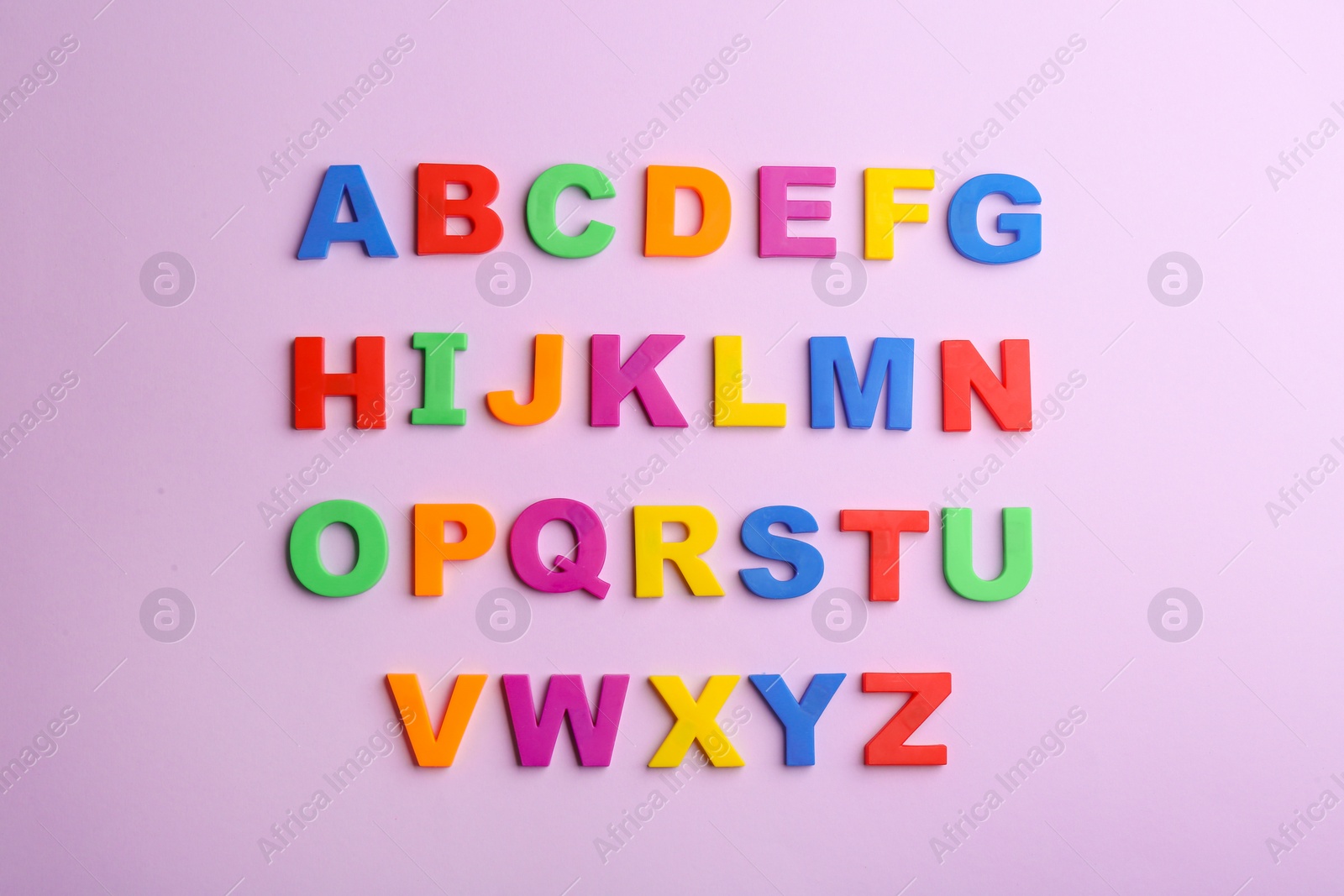 Photo of Colorful magnetic letters on violet background, flat lay. Alphabetical order
