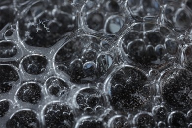 Photo of Many soap bubbles on black background, macro