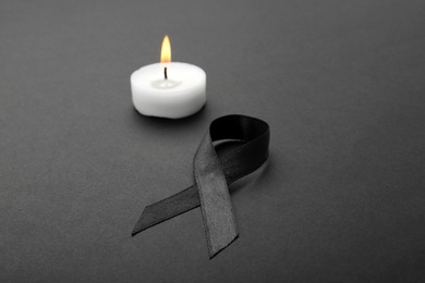 Photo of Ribbon and candle on black background. Funeral symbols