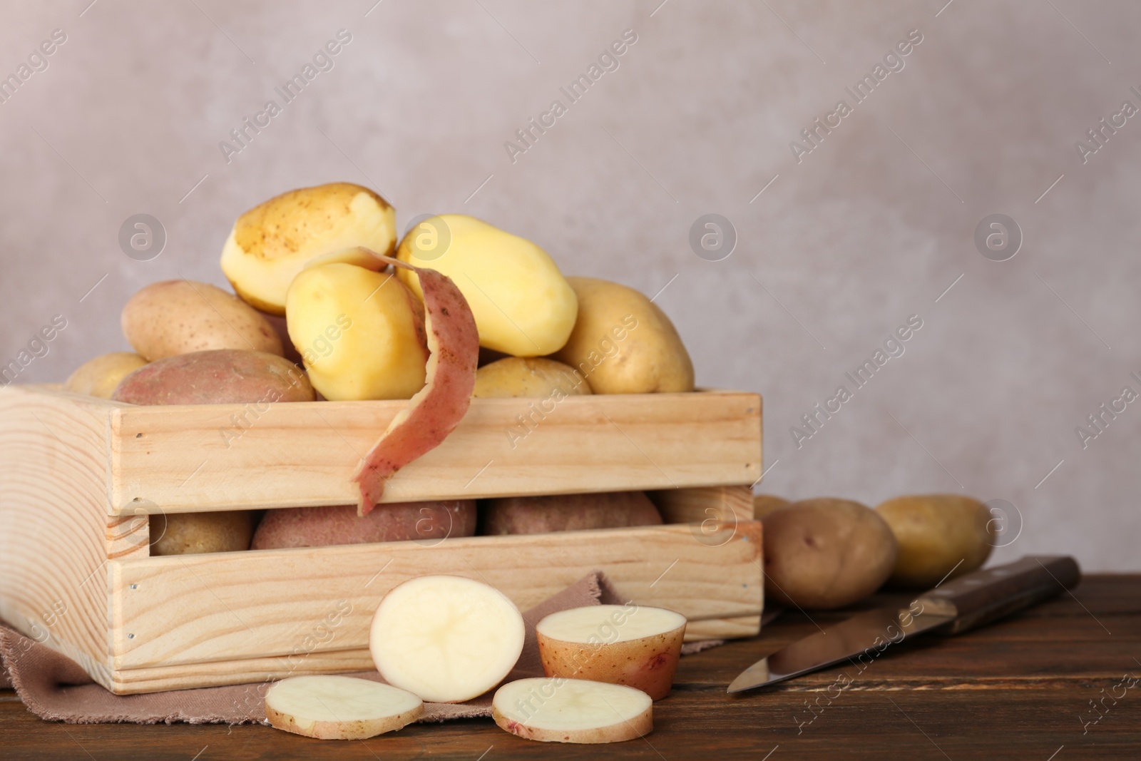 Photo of Fresh organic potatoes in wooden crate on table