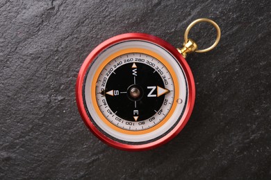 Compass on black textured background, top view. Navigation equipment