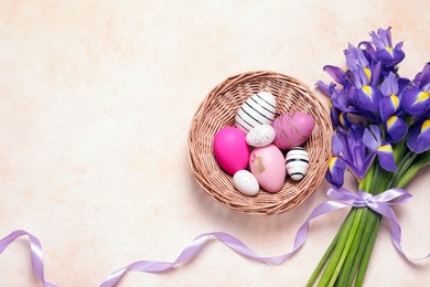 Photo of Flat lay composition with festively decorated Easter eggs and iris flowers on color textured background. Space for text