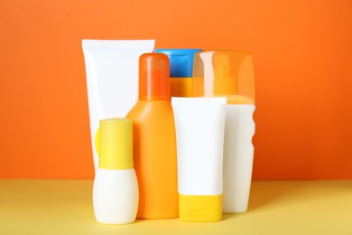 Set of different suntan products on color background