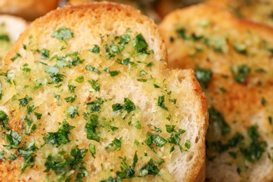 Photo of Slices of toasted bread with garlic and herbs as background, closeup