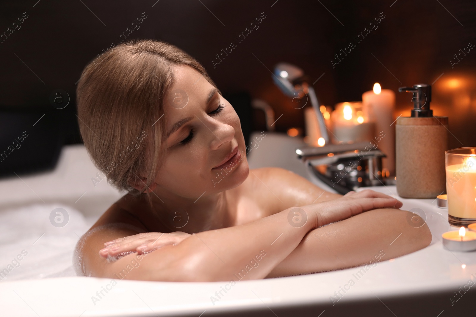 Photo of Beautiful woman taking bubble bath indoors. Romantic atmosphere