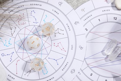 Photo of Zodiac wheel, natal chart, astrology dices and stones on grey table, flat lay