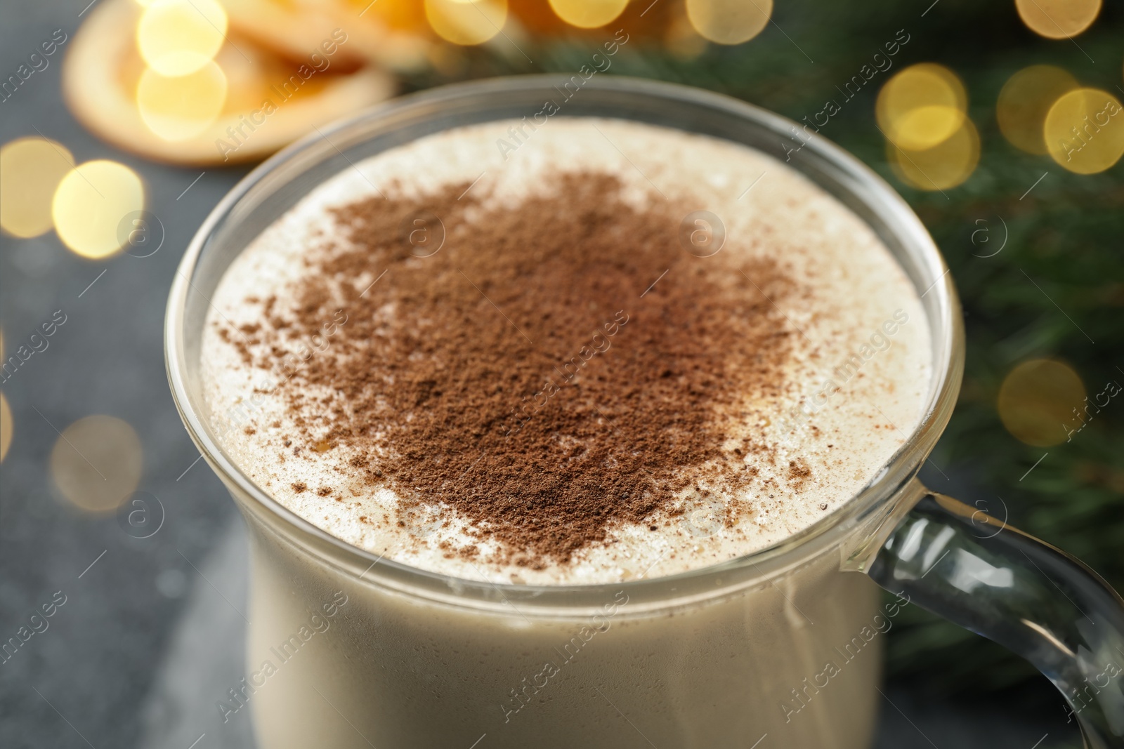 Photo of Glass cup of delicious eggnog with cinnamon, closeup