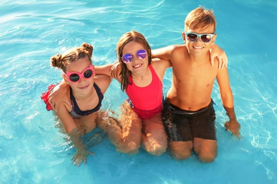 Happy children with sunglasses in swimming pool