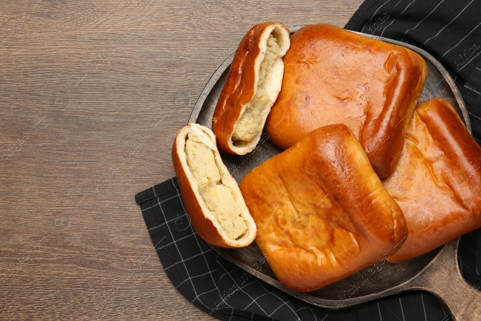 Photo of Delicious baked patties with potato on wooden table, top view. Space for text