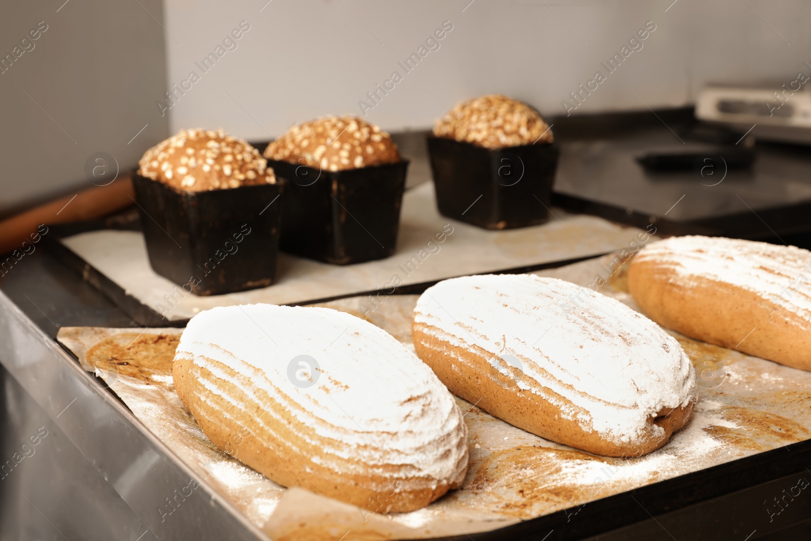Photo of Fresh bread loaves on table in bakery workshop