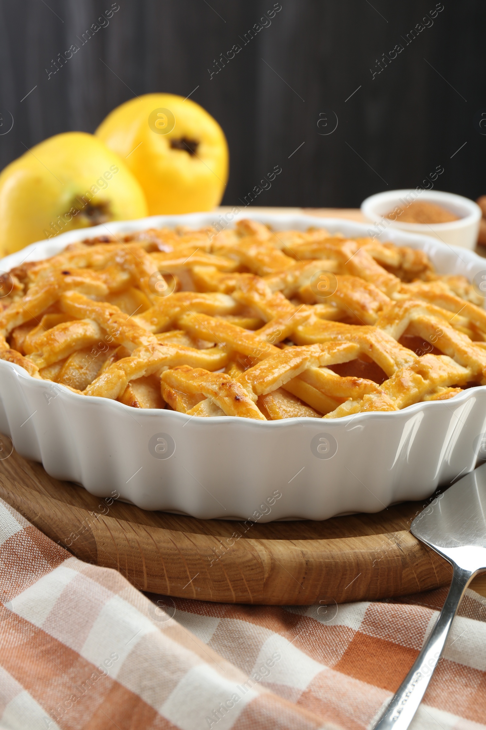 Photo of Tasty homemade quince pie and cake server on table, closeup