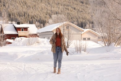 Beautiful young woman on snowy day outdoors. Winter vacation