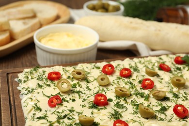 Photo of Fresh natural butter board with cut olives, dill and pepper on table, closeup