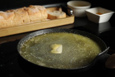 Photo of Melting butter in frying pan on cooktop, closeup