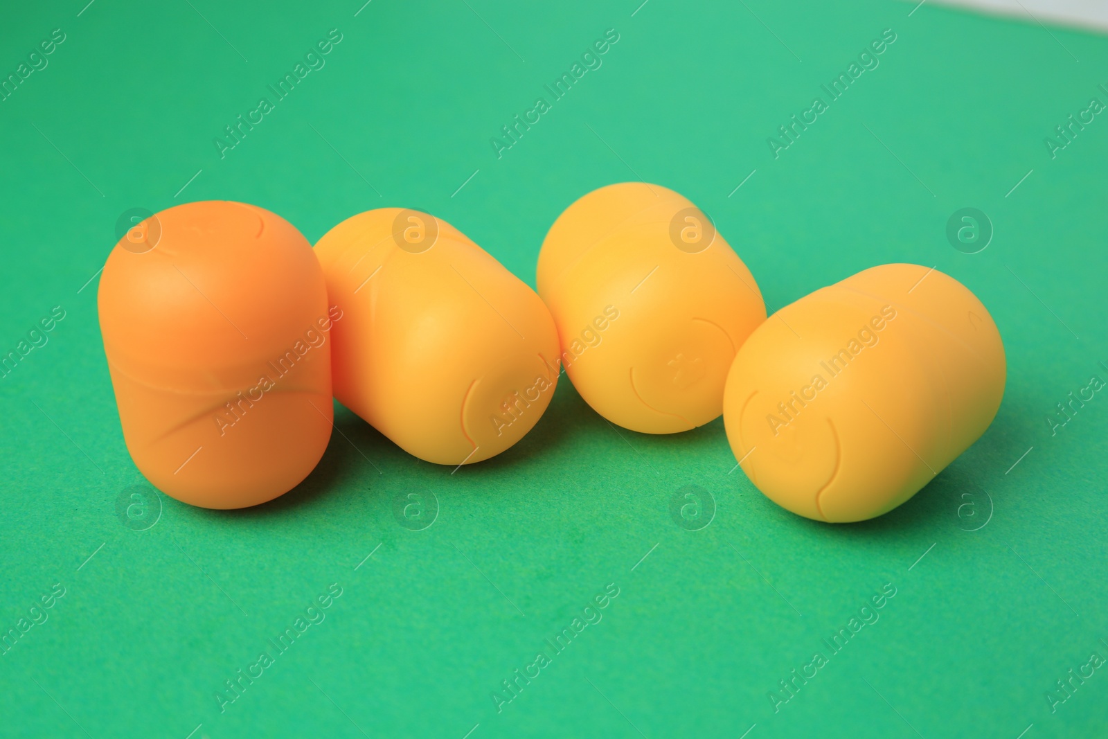 Photo of Sveti Vlas, Bulgaria - June 29, 2023: Plastic capsules from Kinder Surprise Eggs on green background