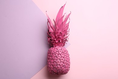 Photo of Pink pineapple on color background, top view. Creative concept