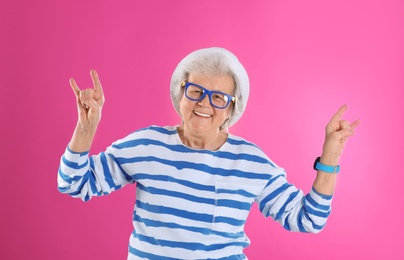 Portrait of cool grandmother on color background