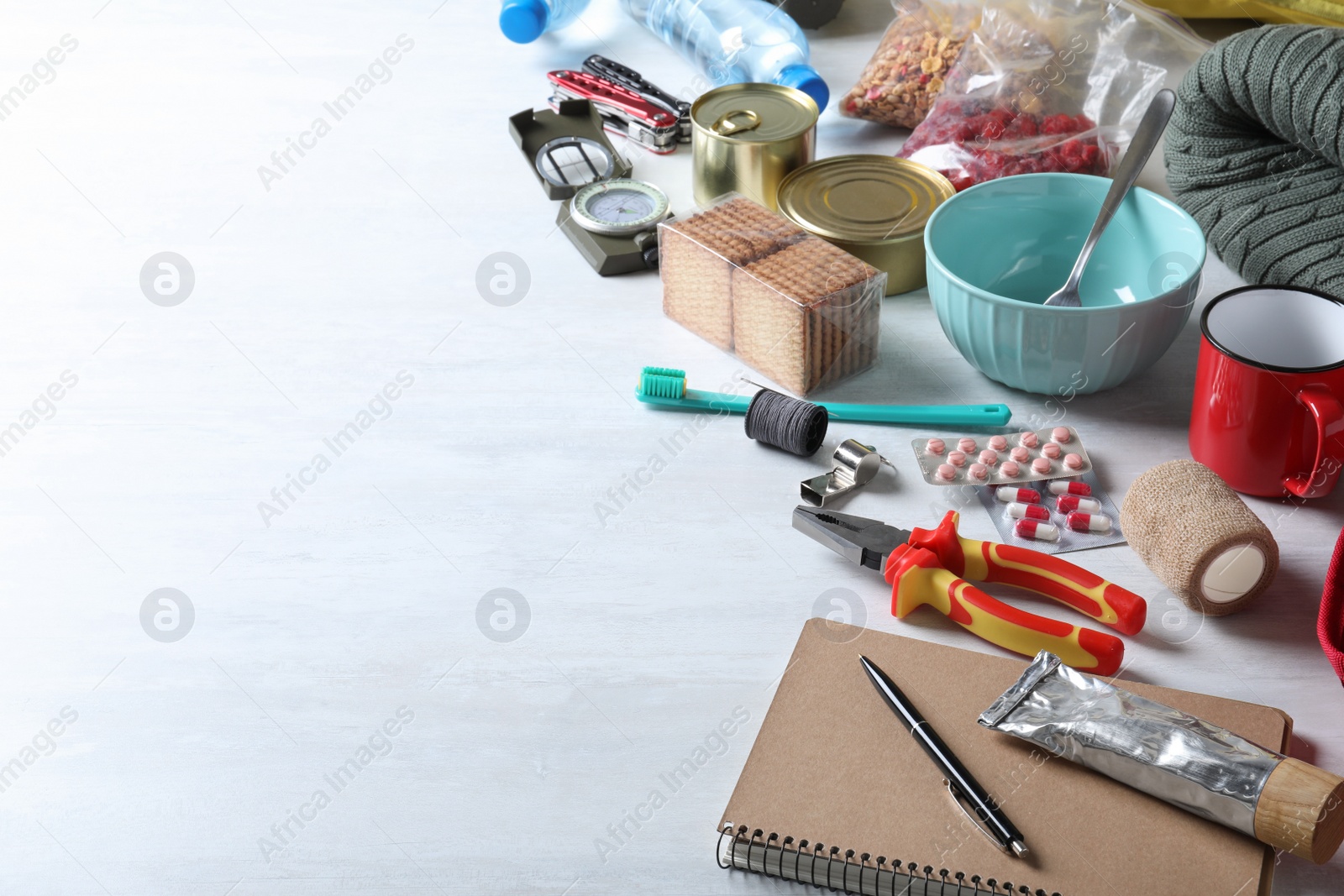 Photo of Earthquake supply kit on white wooden table. Space for text