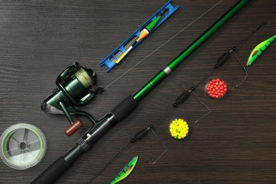 Fishing tackle on dark wooden background, flat lay