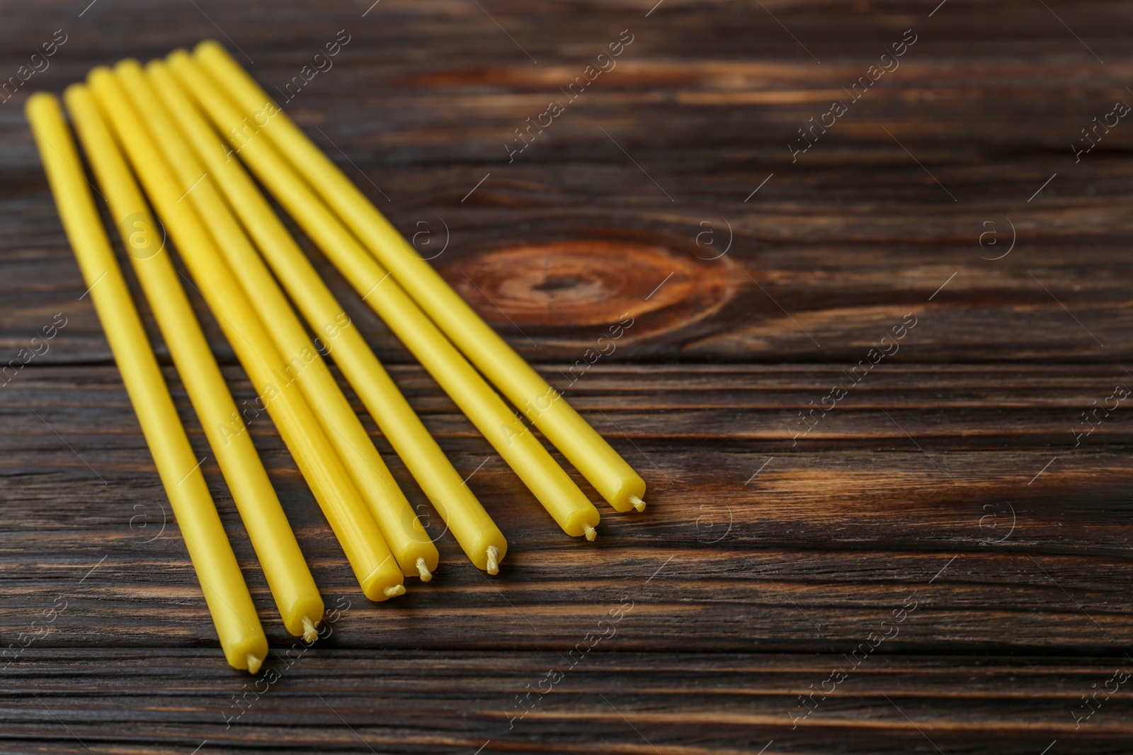 Photo of Church candles on wooden table, closeup. Space for text