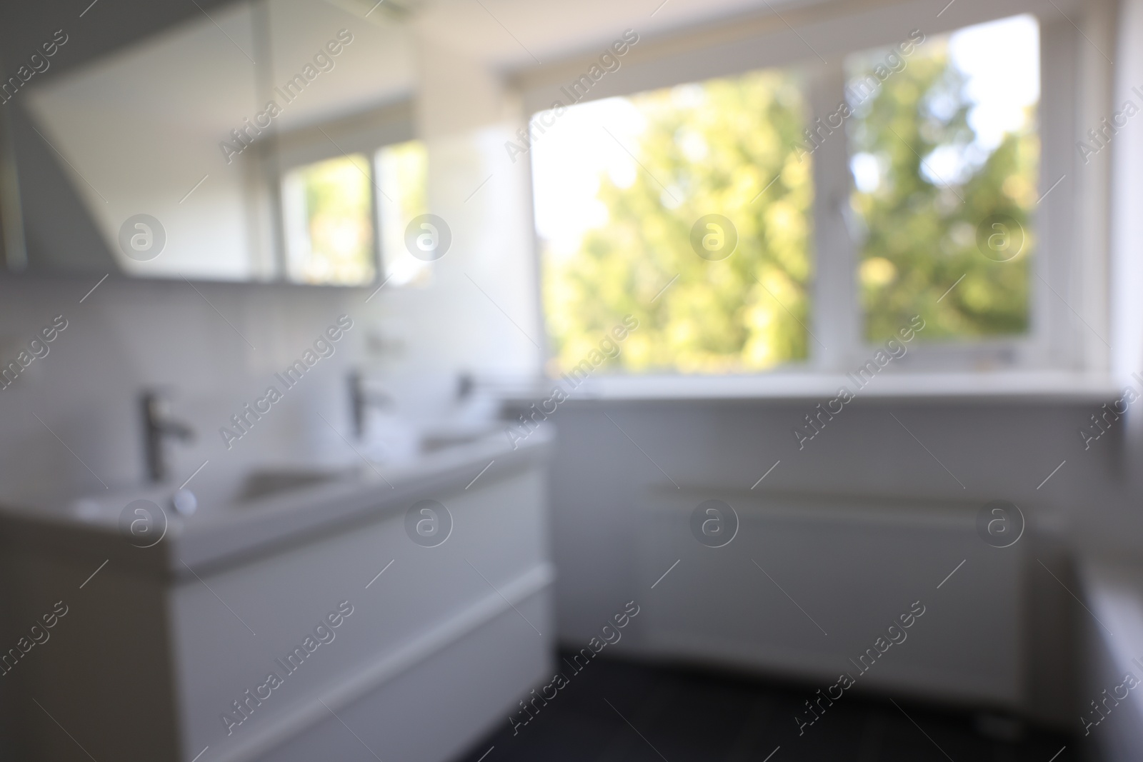 Photo of Blurred view of clean sinks near window in white bathroom