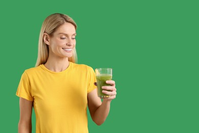 Photo of Woman with glass of tasty celery juice on green background. Space for text