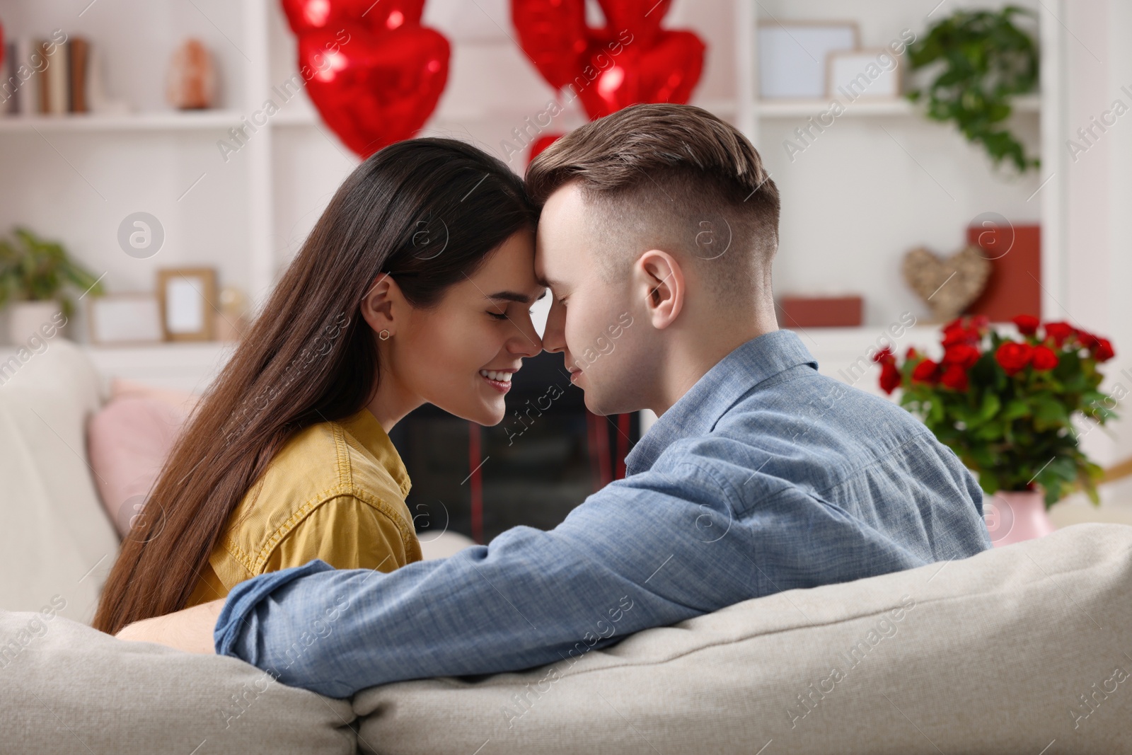 Photo of Lovely couple on sofa at home. Valentine's day celebration