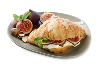 Photo of Delicious croissant with cream cheese, figs and hazelnuts isolated on white