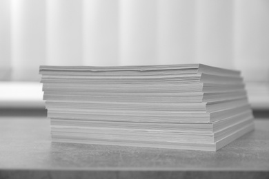 Photo of Stack of paper sheets on grey table, closeup