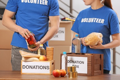 Photo of Volunteers putting food products in donation boxes indoors