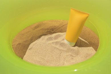 Sunscreen and inflatable ring on sand. Sun protection care