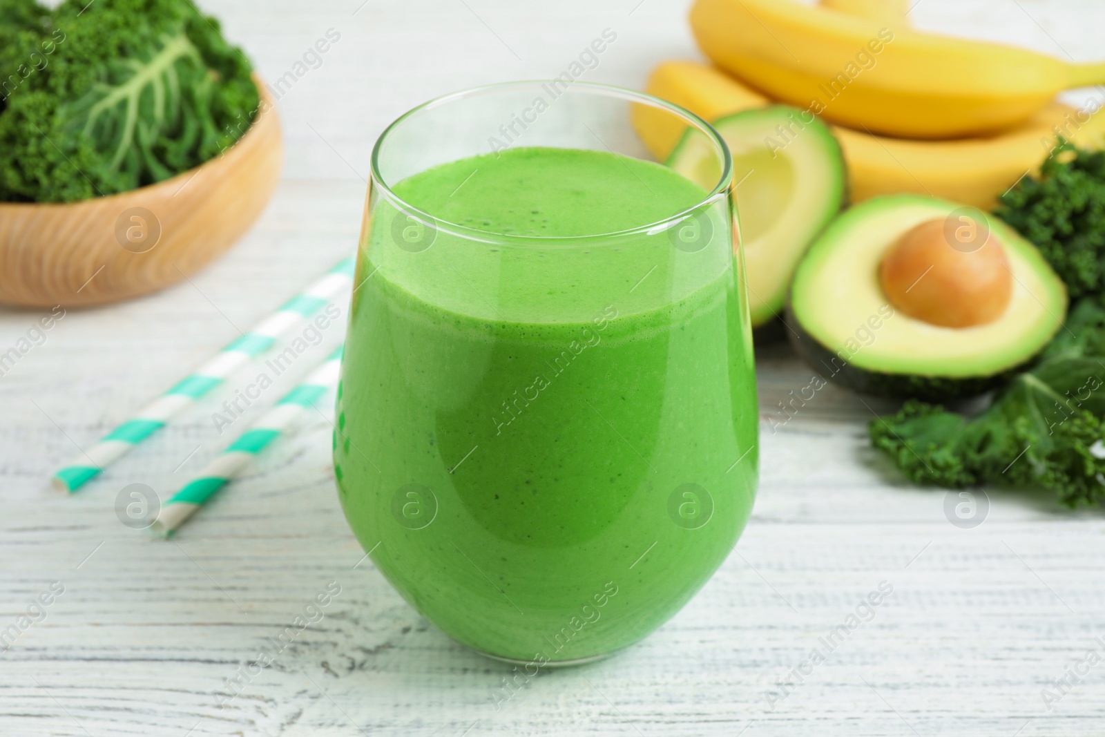 Photo of Tasty fresh kale smoothie on white wooden table, closeup