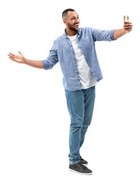 Smiling young man taking selfie with smartphone on white background