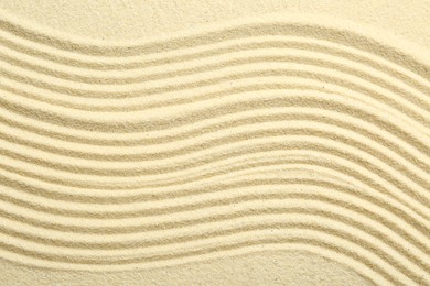 Photo of Zen rock garden. Wave pattern on beige sand, top view