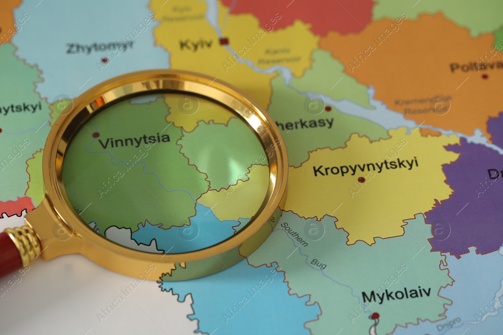Photo of Golden magnifying glass above Vinnytsia region on map of Ukraine, closeup