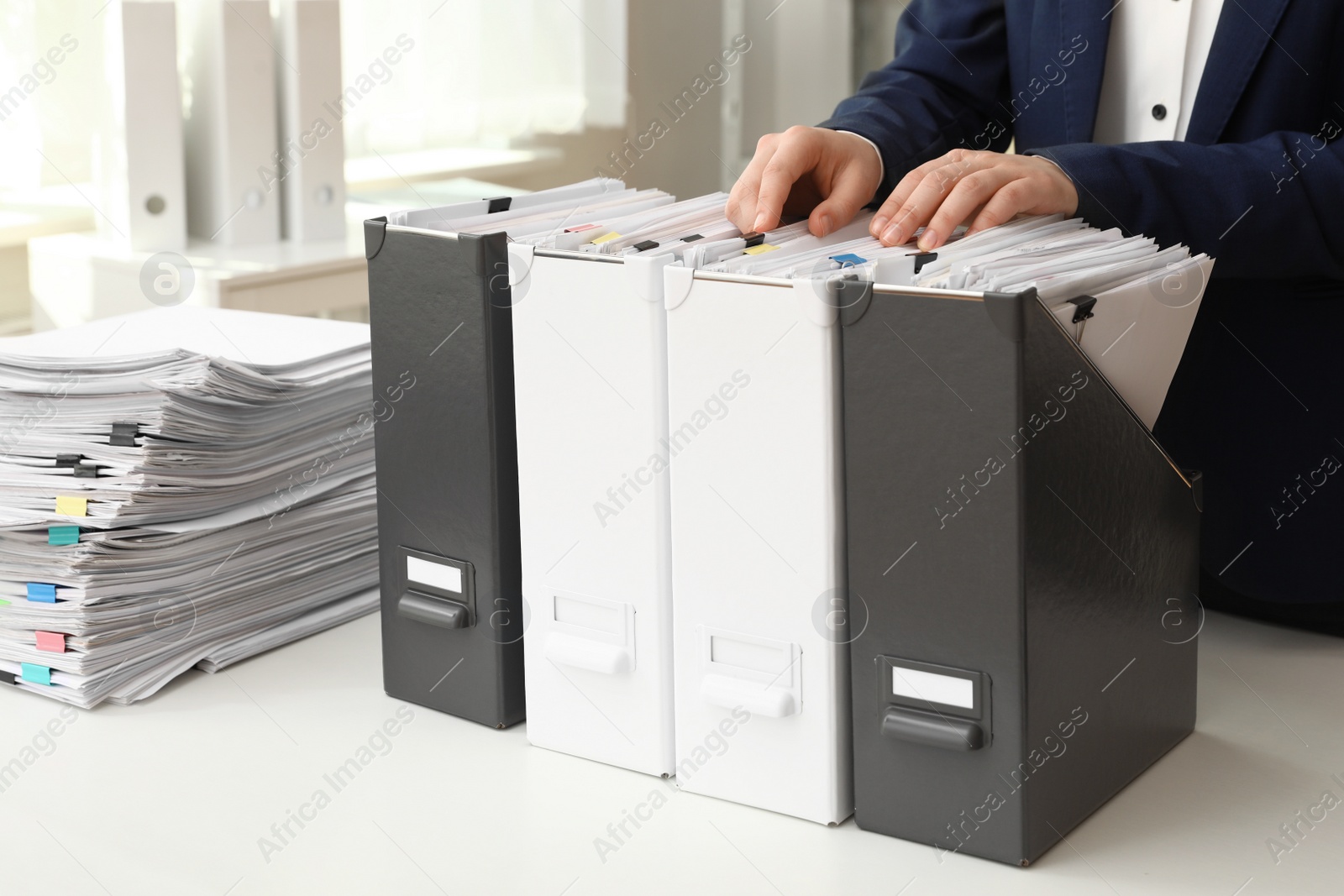 Photo of Woman taking documents from folder in archive, closeup