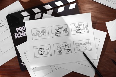 Photo of Storyboard with cartoon sketches at workplace, flat lay. Pre-production process