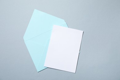 Photo of Letter envelope and card on grey background, top view. Space for text