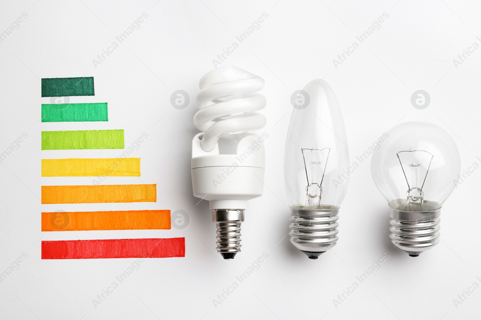 Photo of Flat lay composition with colorful chart and lamp bulbs on white background. Energy efficiency concept