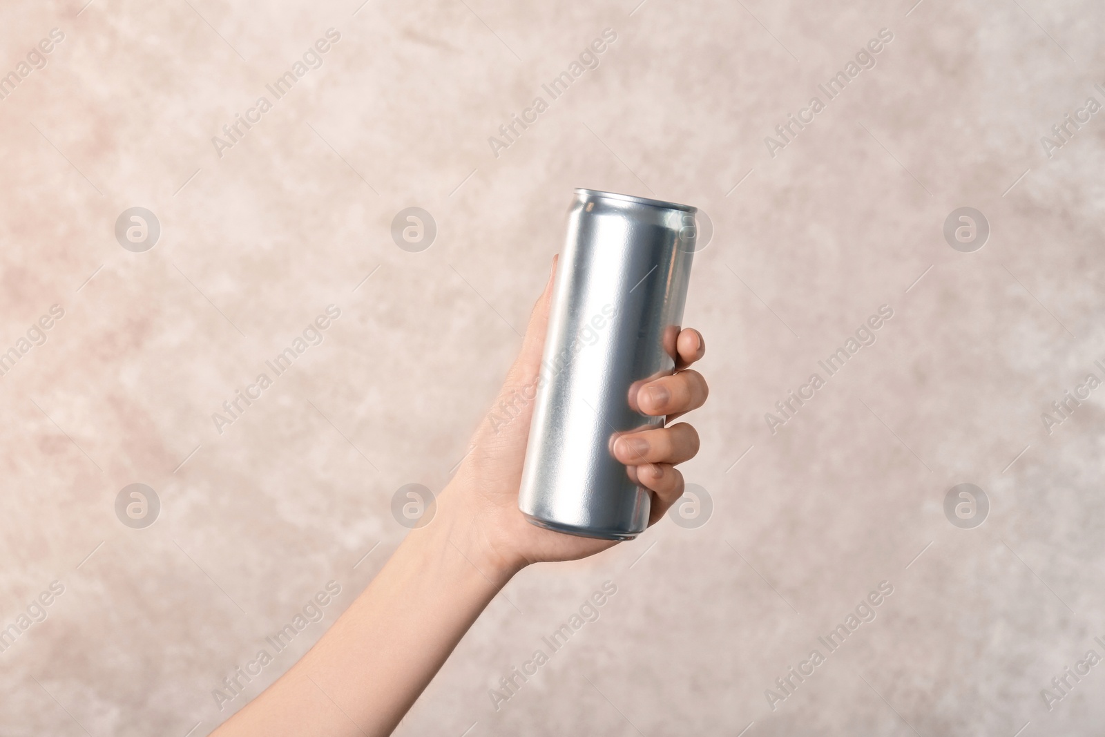 Photo of Woman holding aluminum can on light background