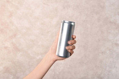 Woman holding aluminum can on light background